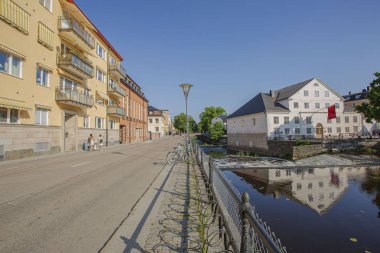 Şehir caddesinin güzel manzarası. Sarı ve beyaz evler su yüzeyine yansıtmaktadır. Arka planda bulutsuz mavi gökyüzü. Muhteşem doğa manzara arka planlar.