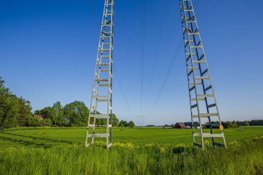 Yüksek voltaj iletim hattı. Yeşil alanlar, yeşil orman ağaçları ve mavi gökyüzü ile manzara güzel görünümü. Muhteşem arka planlar. İsveç. Avrupa