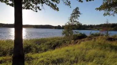 Yaz gününde gölde gün batımının muhteşem manzarası. Göl ve gökyüzü ufukta birleşiyor.