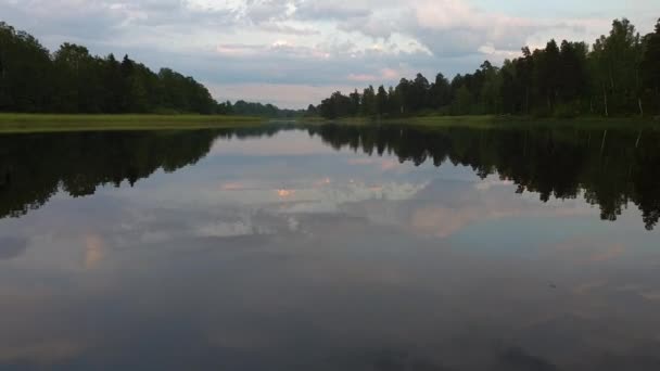 穏やかな夏の夜に自然の風景のゴージャスな眺め クリスタルクリーンミラー水面に反射する緑の木や植物と湖岸 激しい雷雲に覆われた空 — ストック動画
