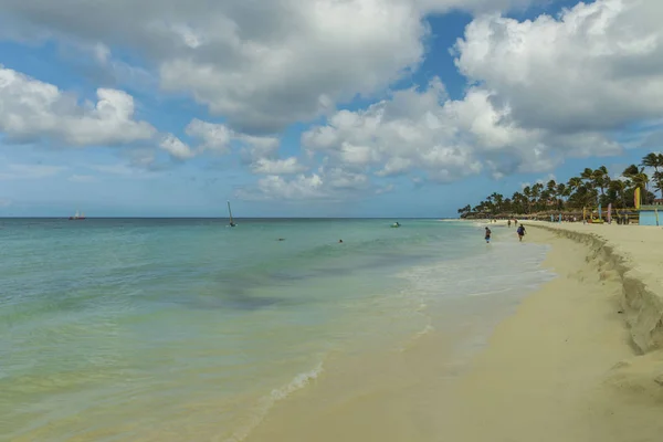 緑のヤシの木と青い空の背景に白い砂浜とターコイズブルーの波 アルバ島のイーグルビーチ 美しい自然背景 — ストック写真