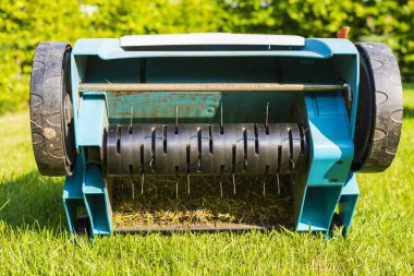 Yeşil çimenlikteki elektrikli çim makinesinin yakın görüntüsü izole edilmiş. Bahçe makineleri kavramı. 