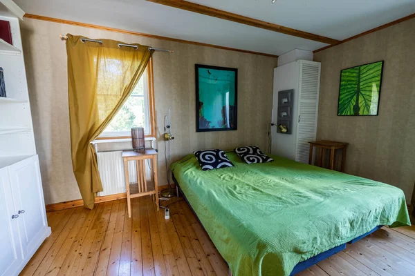 View of bedroom with double bed covered with green cloth in summer house. Interior concept background.