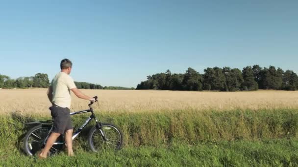 Közelről Láthatjuk Rozsmezőn Bicikliző Férfit Rozs Mező Egybeolvad Kék Éggel — Stock videók