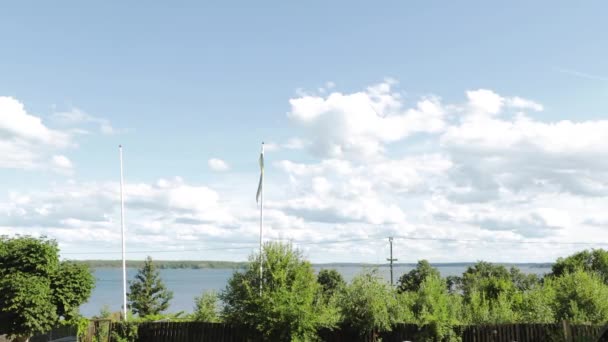 Krásný výhled na přírodu. Nádherné Baltské moře vodní hladiny, švédská vlajka vlnící se ve větru zelené lesní stromy a modré nebe s bílými mraky pozadí.