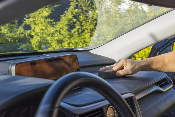 Close up view of male hand polishing inside of car.