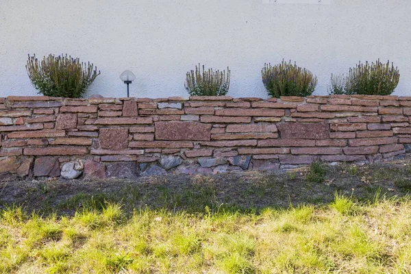 Красивый Вид Декоративную Каменную Стену Цветами Уличными Фонарями — стоковое фото