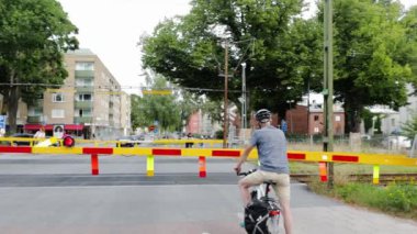 Yaz günü güzel şehir manzarası. İnsanlar ve arabalar tren geçidinde kırmızı ışıkta hız trenini bekliyor. 08.22.2020. Uppsala. İsveç.