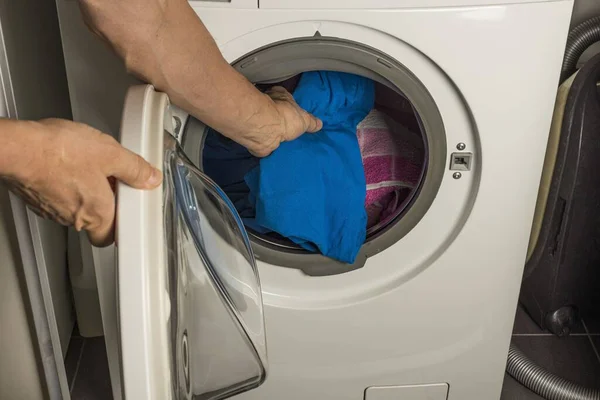 男人在洗衣机里洗衣服的景象 家庭常规概念 — 图库照片