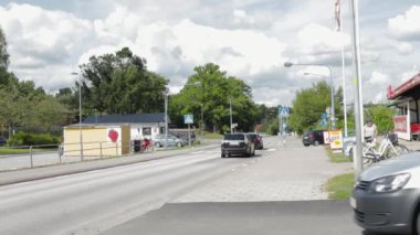 Bulutlu bir yaz gününde tipik İsveç köyünün güzel manzara manzarası. İnsanlar asfalt yoldan geçiyorlar. 08.06.2020. Geta. İsveç