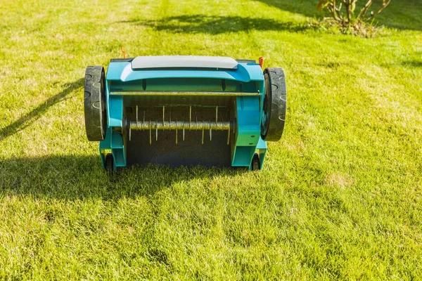 Yeşil çimenlikteki elektrikli çim makinesinin yakın görüntüsü izole edilmiş. Bahçe makineleri kavramı. 