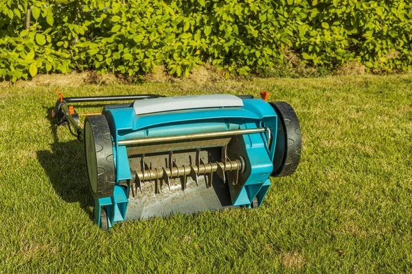 Yeşil çimenlikteki elektrikli bahçe spreyinin görüntüsü izole edilmiş. Bahçe makineleri kavramı. 