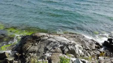 Ağır çekim. Baltık Denizi 'nin taşlara çarptığı güzel bir manzara. Muhteşem doğa manzarası. İsveç.