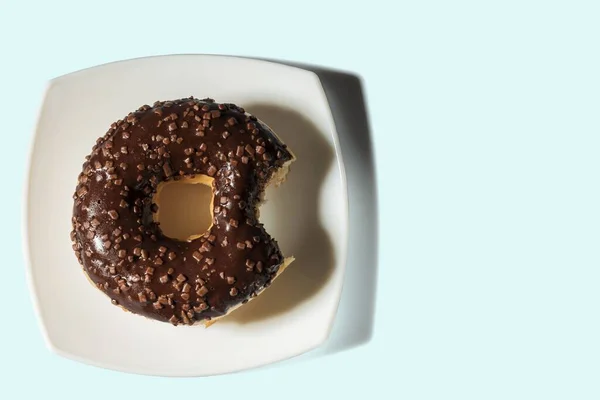 Nahaufnahme Von Gebissenen Donut Auf Weißem Teller Isoliert Auf Blauem — Stockfoto
