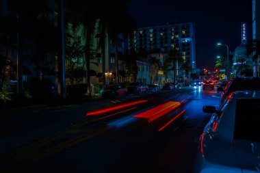 Gece vakti Miami Plajı şehir manzarası, Collins Bulvarı boyunca giden arabalardan büyüleyici bulanık ışık yolları. ABD.