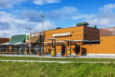 McDonalds restoran binası. Güneşli bir günde arka planda McCafe ve açık hava oturma alanı var.. 