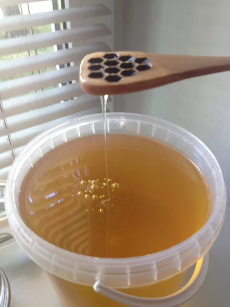 fresh golden honey with wooden spoon season