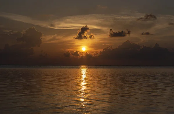 Gün batımında Maldivler. Deniz, bulutlar, siluetler. İlkbahar, 2019