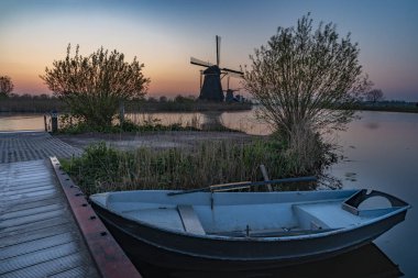 Altın saat gün doğumunda kinderdijk kanalın bankında güvenlik teknesi park