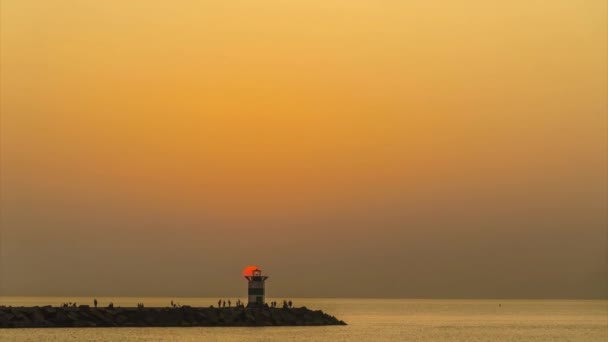 灯台キャンドルライトコンセプト 鮮やかな夕日 キャンドルのようなスケベニンゲン灯台の上の日の出 — ストック動画