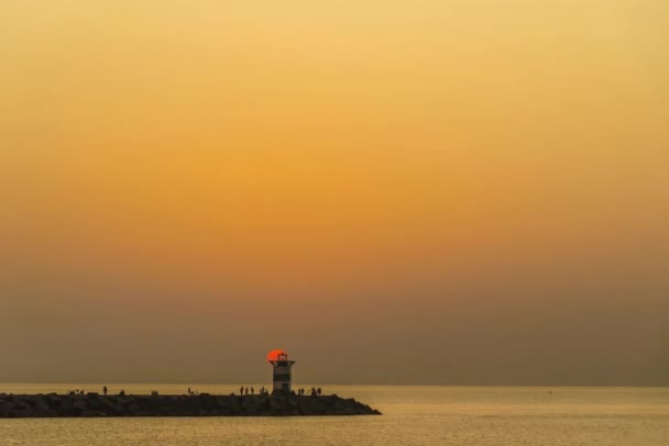 灯台キャンドルライトコンセプト 鮮やかな夕日 キャンドルのようなスケベニンゲン灯台の上の日の出 — ストック動画