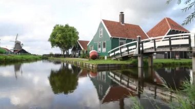 Cheese factory building at Zaanse Schans reflected on the calm canal water, in Zaandam, Neterlands