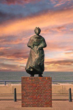Balıkçıların anıtı deniz ve okyanuslarda kanlı turuncu bir günbatımı gökyüzünün altında Scheveningen, Hollanda 'da öldü.
