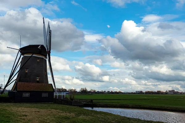 Голландская ветряная мельница сталкивается с ветром и работает турбины для откачки воды — стоковое фото