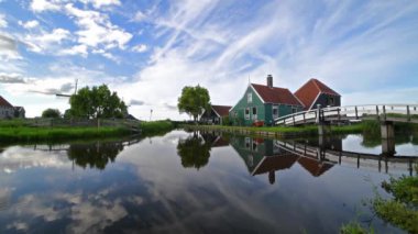 Hollanda 'daki sakin kanal suyundaki kırsal evlerin yansıması.