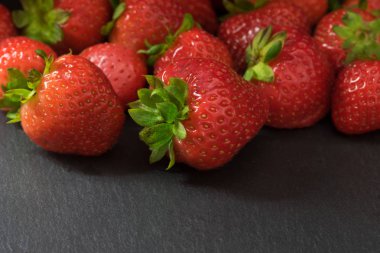 Grup taze çilek fotoğrafın üst yarısında doldurur. Metniniz için fotoğraf hazır altındaki karanlık masam.