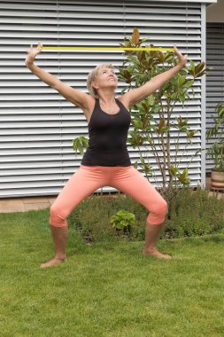 Sarışın kadın kıdemli bir ruber açık bahçe ile egzersiz