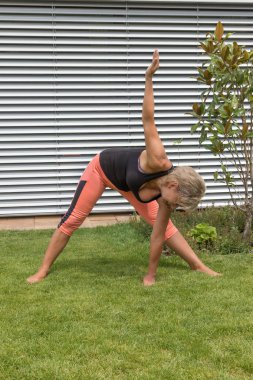 Ona yaptığını çekici sarışın kadın kıdemli derin bir yay uzanır ve çim bir el tarafından dokunur. Dikey olarak. 