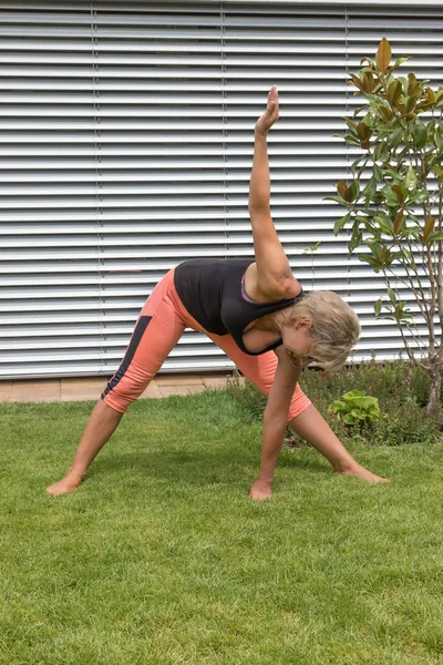Ona yaptığını çekici sarışın kadın kıdemli derin bir yay uzanır ve çim bir el tarafından dokunur. Dikey olarak. 