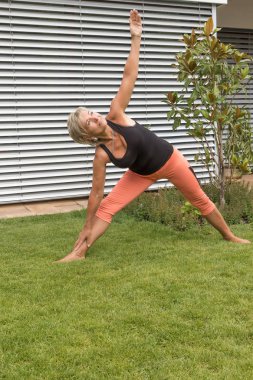 Çekici sarışın kadın kıdemli fitness açık havada bir öncüsü çalışıyor