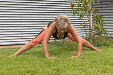 Ona yaptığını çekici sarışın kadın kıdemli yaka açık havada gösterilen derin bir yay uzanır