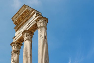 Forum Romanum ikonik üç sütun metniniz için ücretsiz yer ile mahveder. Roma. İtalya. Mavi gökyüzü arka planda. Yatay olarak.