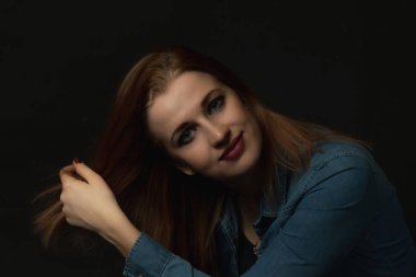 Gülümseyen genç çekici kadın uzun saçlı düşük anahtar portresi. Siyah arka plan üzerine başka bir şey. 