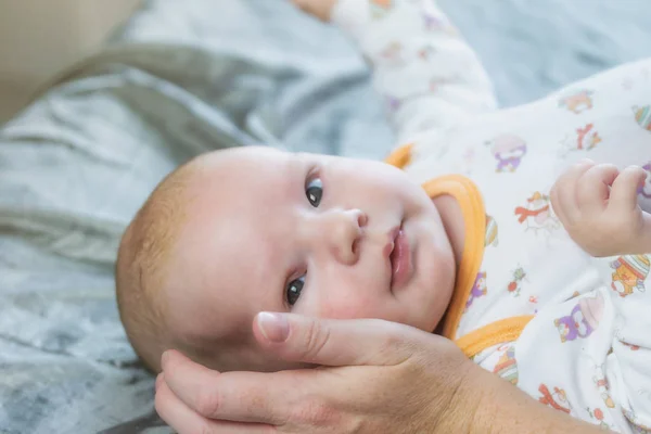 Поглаживание новорожденного ребенка, лежащего на одеяле — стоковое фото