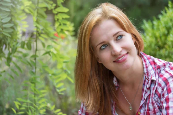 Gülümseyen genç kadın sağ üst köşesine bakıyor 