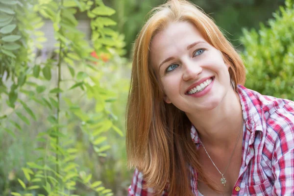 Gülen genç kadın sağ üst köşesine bakıyor