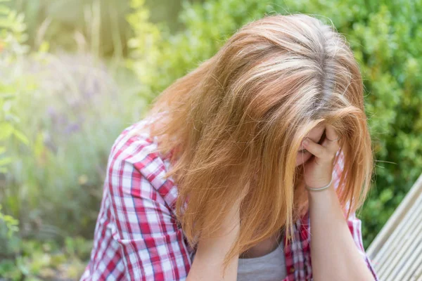 Mujer joven deprimida sosteniendo sus manos sobre su cabeza —  Fotos de Stock