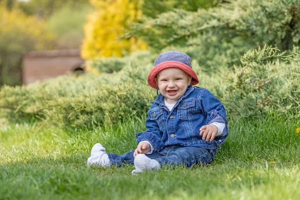 Lachender Süßer Kleiner Junge Sitzt Draußen Und Schaut Die Kamera — Stockfoto