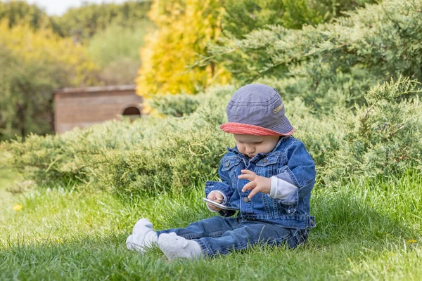 Lindo Niño Pequeño Sentado Aire Libre Está Utilizando Teléfono Inteligente —  Fotos de Stock