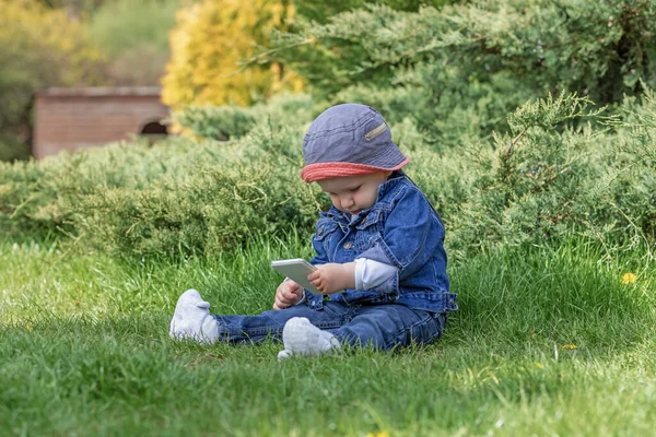 Aranyos Kisfiú Használja Okos Telefon Füvön Kertben — Stock Fotó