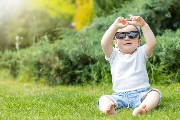 Glimlachend Jongetje Buiten Zittend Een Zonnebril — Stockfoto