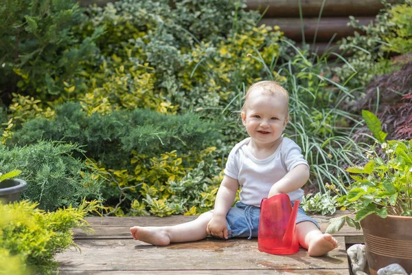 Lächelnder Kleiner Junge Sitzt Garten Mit Garten Gießkanne Und Blickt — Stockfoto