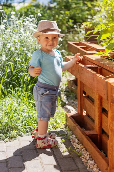 Ein Lächelnder Kleiner Junge Posiert Neben Einem Hochbeet Vertikal — Stockfoto