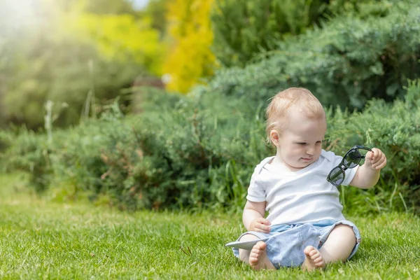 Niño Está Viendo Sus Gafas Sol Sentadas Jardín —  Fotos de Stock