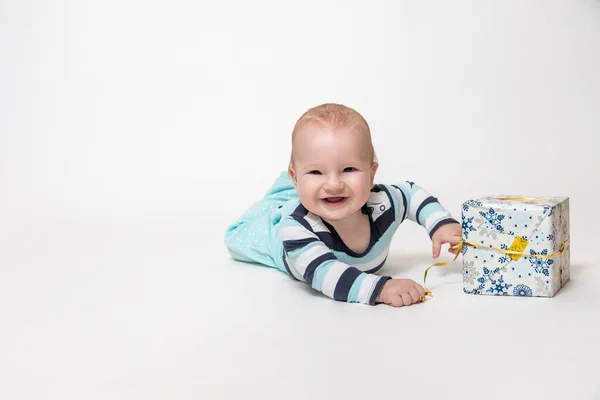 Uśmiechnięty Chłopczyk Trzyma Świąteczną Paczkę Podłodze Wszystko Jest Białym Tle — Zdjęcie stockowe