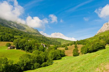 On the climb route to the emblematic Picu Urriellu (Naranjo de Bulnes), we find impressive views of green valleys, fields and rocky mountains. Collado de Pandebano, Picos de Europa, Asturias, Spain clipart